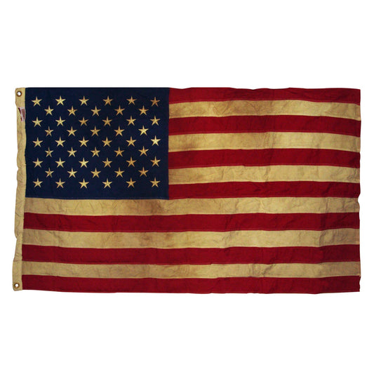 Vintage American flag with visible wear on a white background