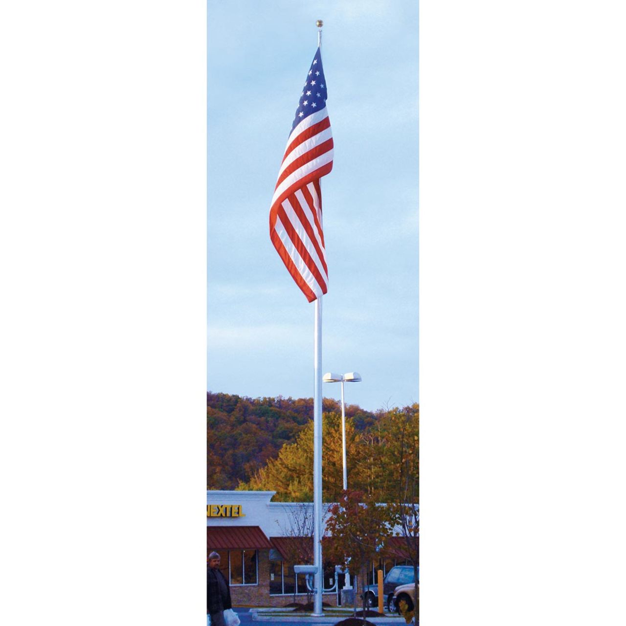 American flag on a flagpole with a building and trees in the background