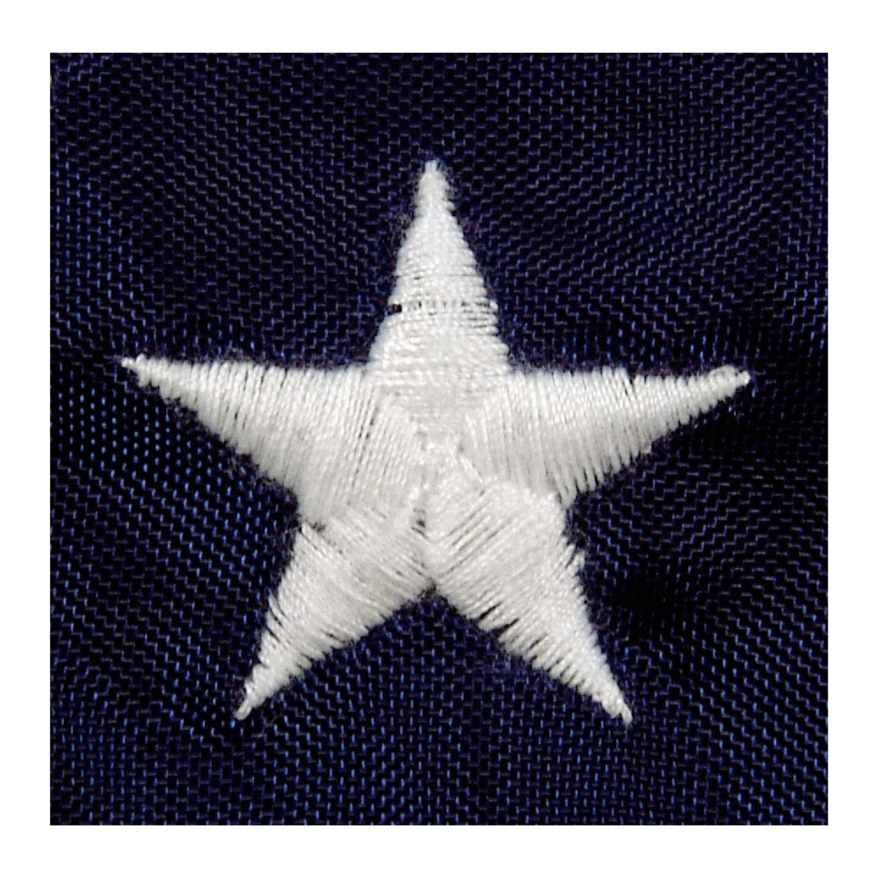 Close up of a white embroidered star on the blue canton of an American flag