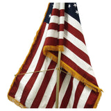 American flag with gold fringe on a white background