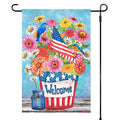 Decorative garden flag with flowers, birds, and an American flag on a blue background.