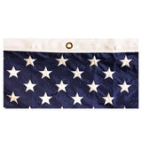 Close up of a grommet on white fabric edge of an American flag featuring a close up of the blue canton and white stars