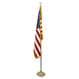 Indoor American flag with gold fringe on a gold pole with an eagle finial and base.