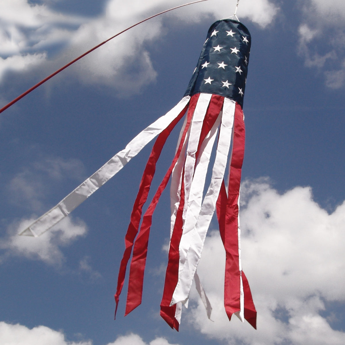 American flag windsock against a blue sky with clouds