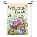 Garden flag with 'Welcome Friends' text, flowers, wheelbarrow, and watering can on a light green background.
