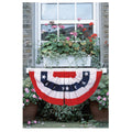 American flag bunting hanging in front of a window with flower boxes.