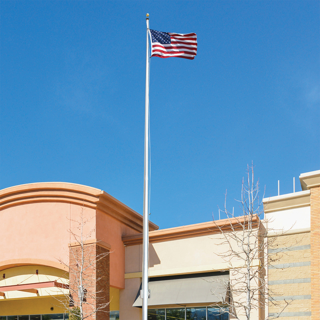 A 25ft flagpole with a stationary truck, displaying an American flag, installed in front of a building.