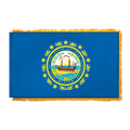State of New Hampshire flag featuring the full-color state seal with the frigate Raleigh, a laurel wreath, and 'Seal of the State of New Hampshire 1776' text on a solid dark blue field.  This flag features yellow fringe.