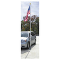 Silver minivan parked on a driveway with an American flag on a pole.