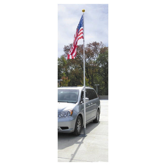 Silver minivan parked on a driveway with an American flag on a pole.