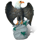 Statue of an eagle perched on a rock with a white background