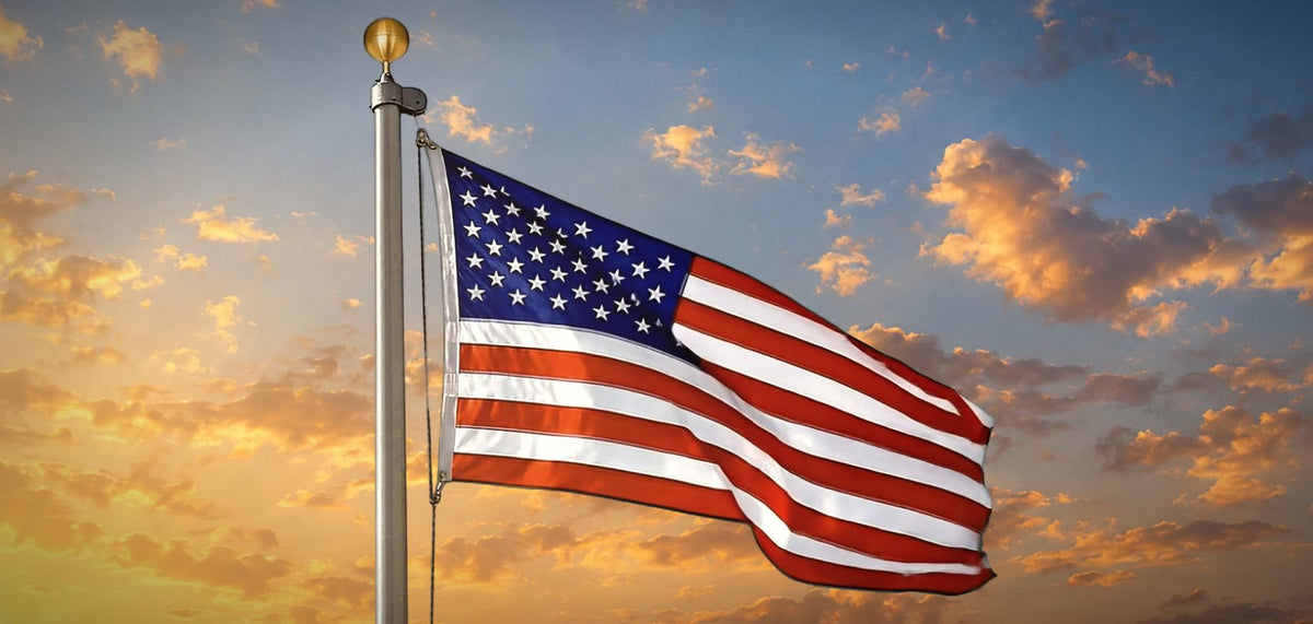 An American flag flying on its pole at sunrise